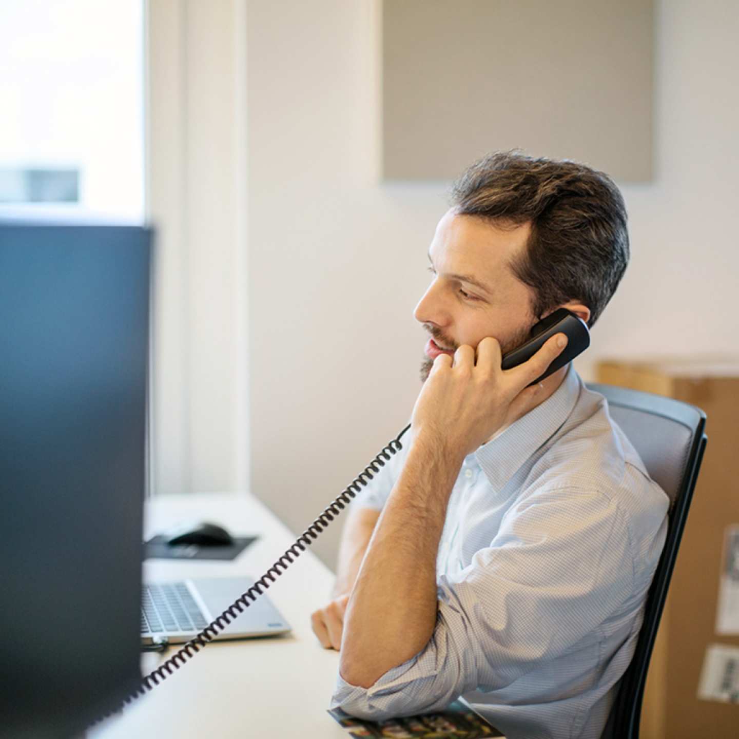 Worker talking on desk phone.