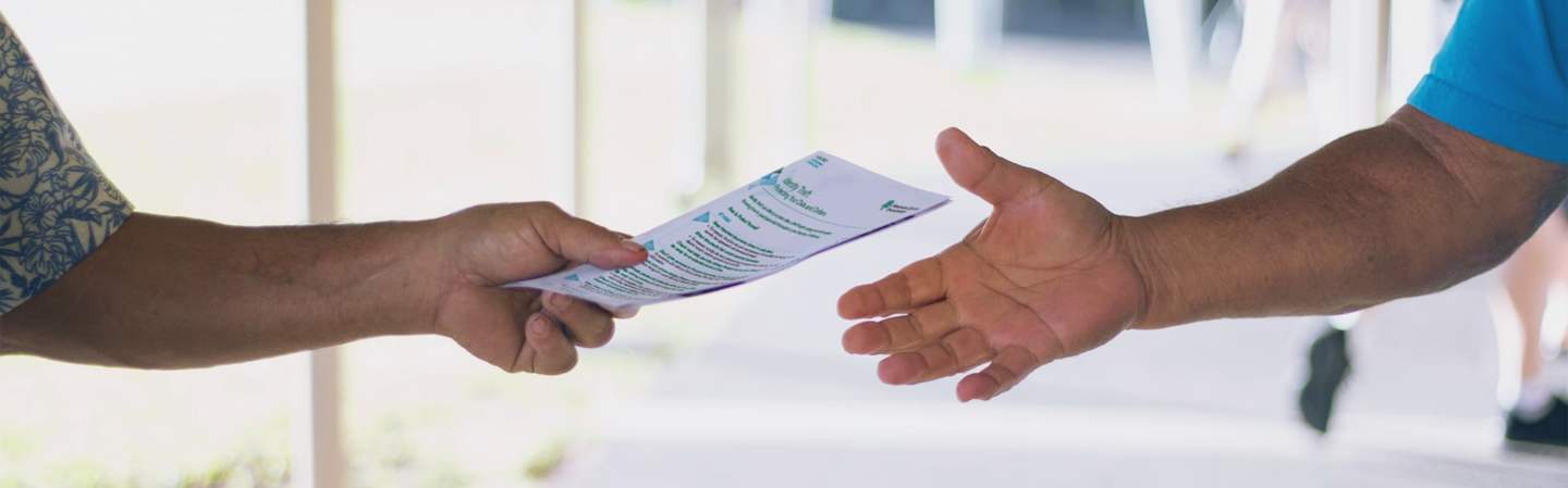 Two people exchanging paperwork.