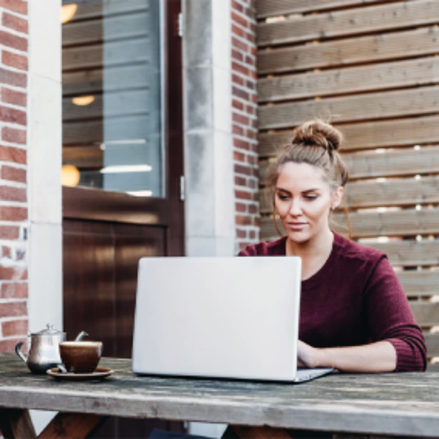 A woman sitting at her desk typing on her laptop.