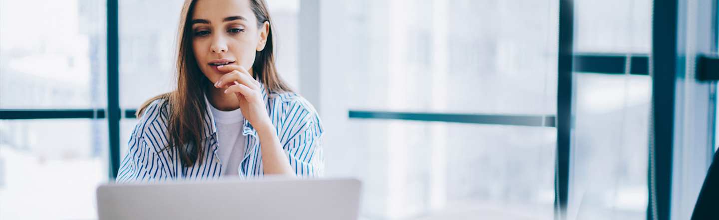 Woman working on laptop in office.