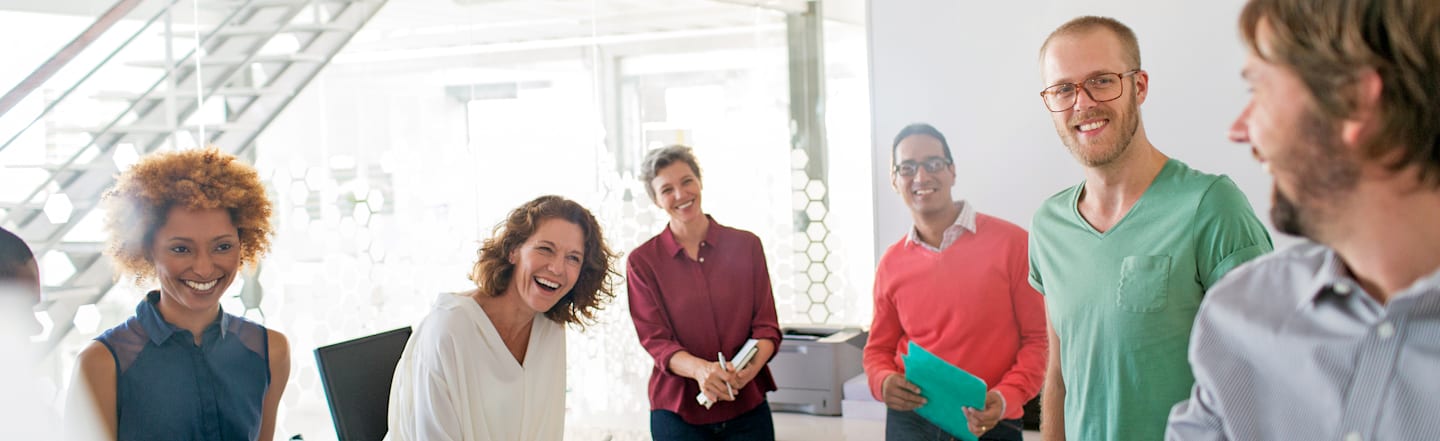 Co-workers laughing during after-meeting discussion.