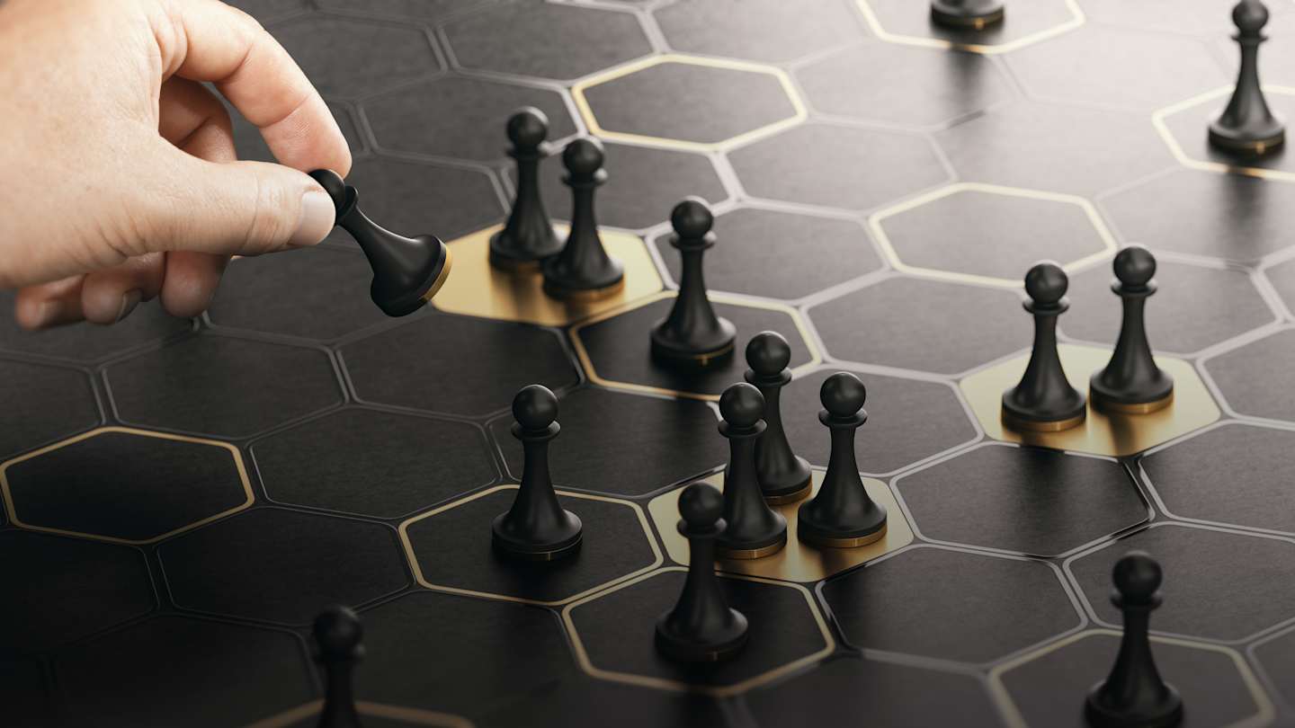 Hand moving pawns on stylized chess board.