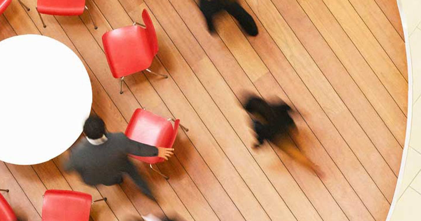 People in an office gathering around a table.