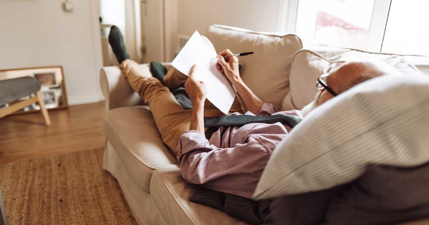 Man on couch with notebook.