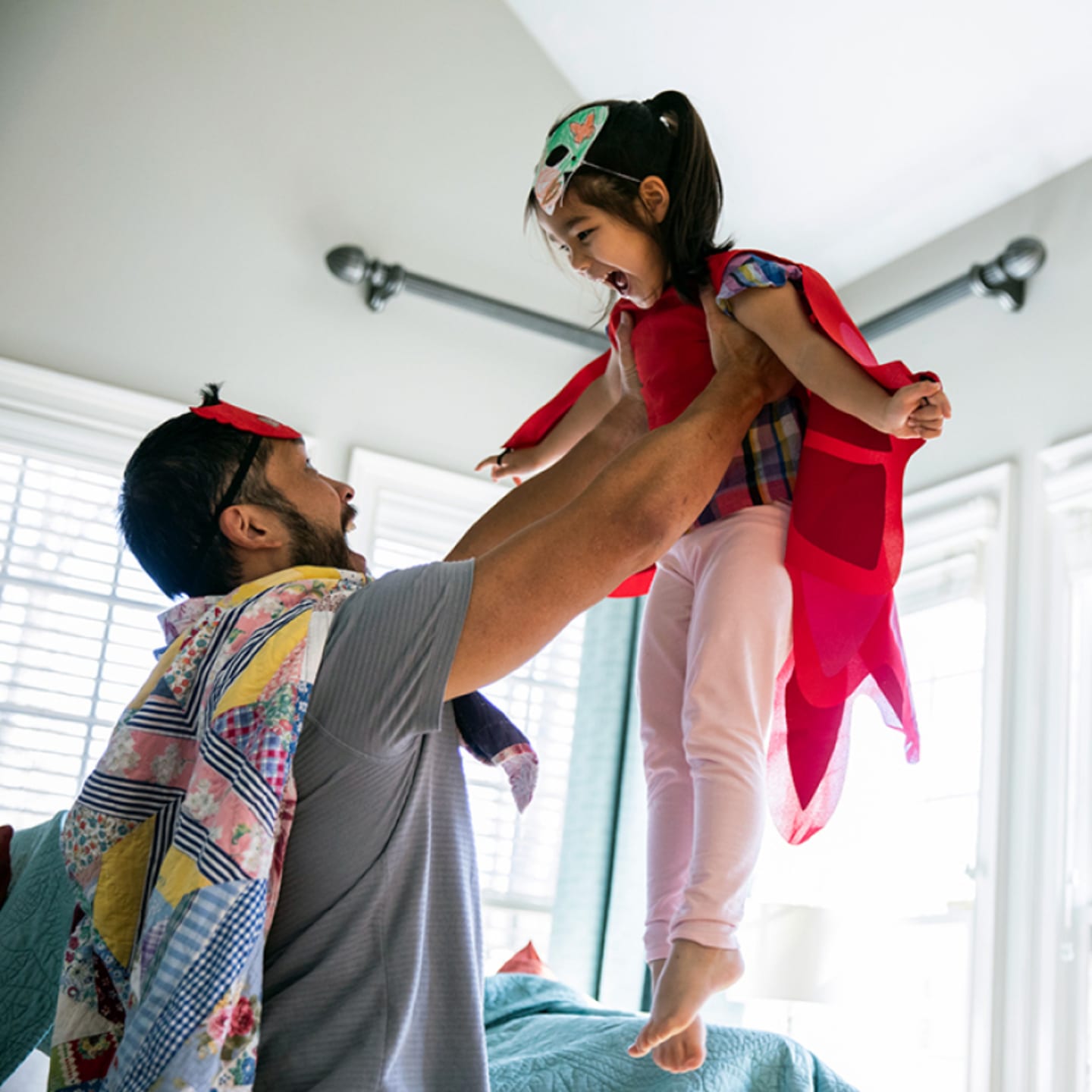 Father playing dress-up with young daughter.