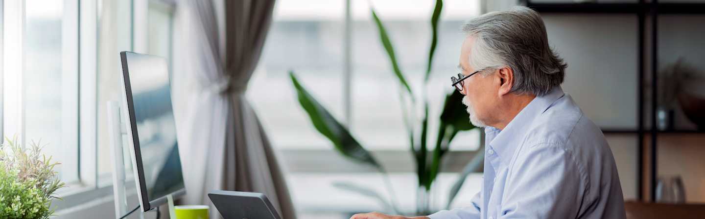 Man on desktop computer at home.