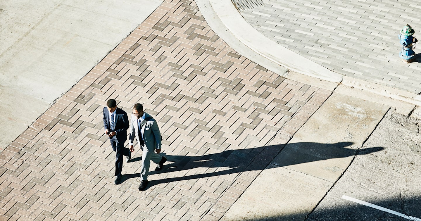 Business men walking on city street. 