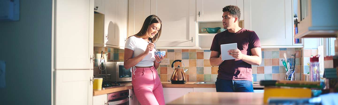 Couple talking in home kitchen.