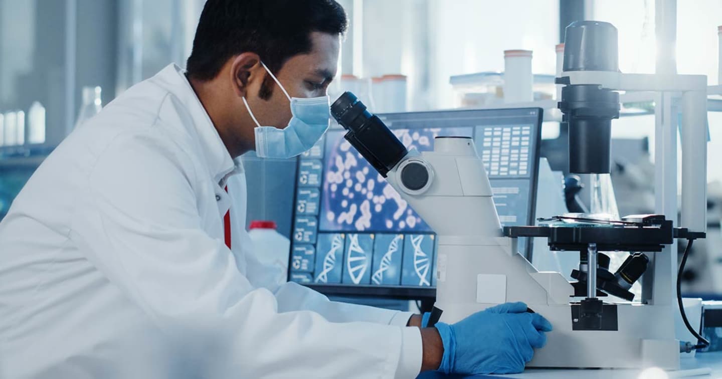 Scientist looking through a mircoscope.