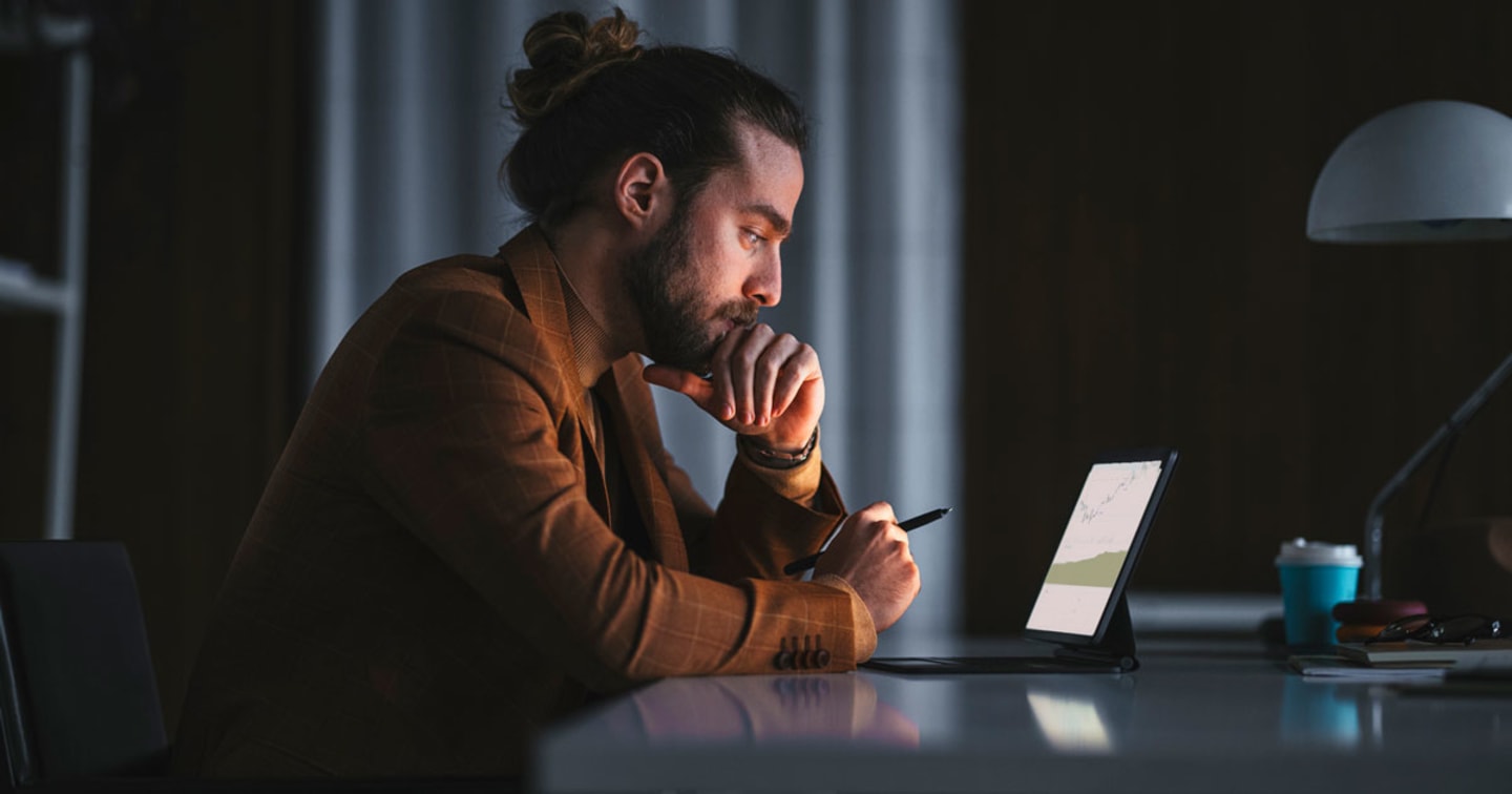 Man looking over charts on a tablet. 