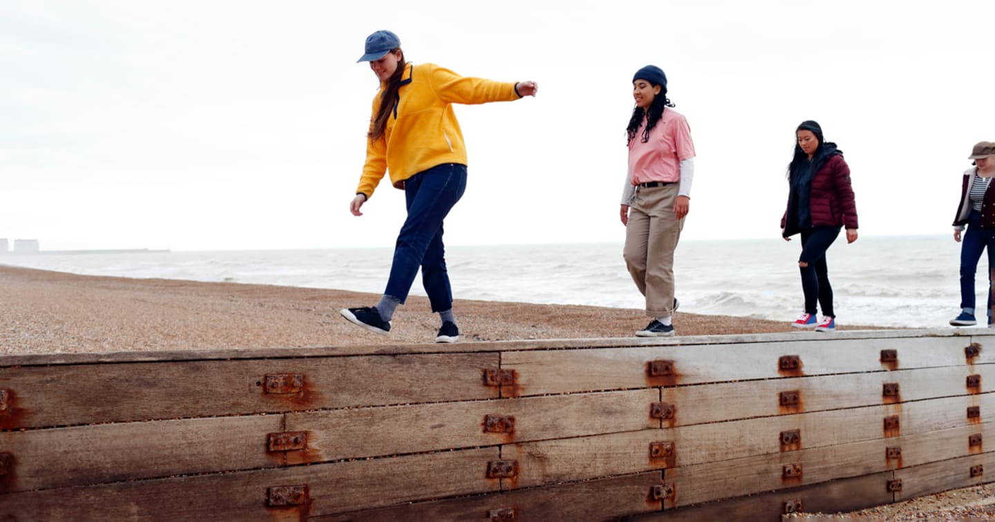 Group of friends walking on beach.