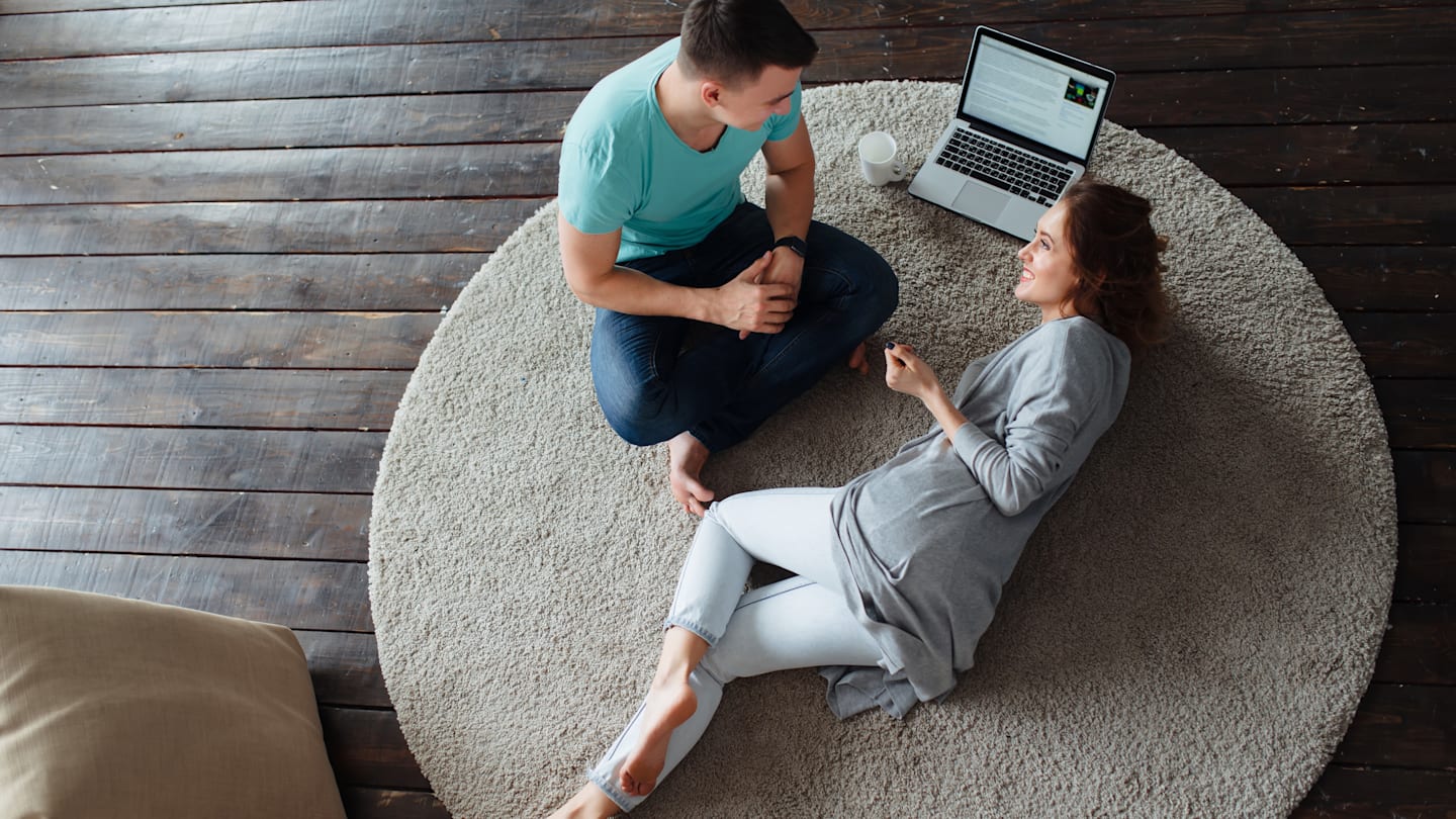Couple having discussion on living room floor with 