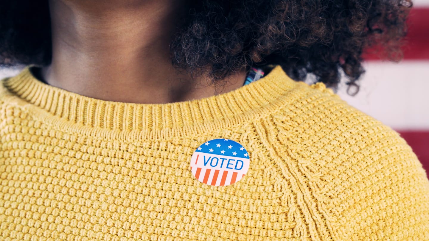 Woman wearing an "I Voted" sticker.