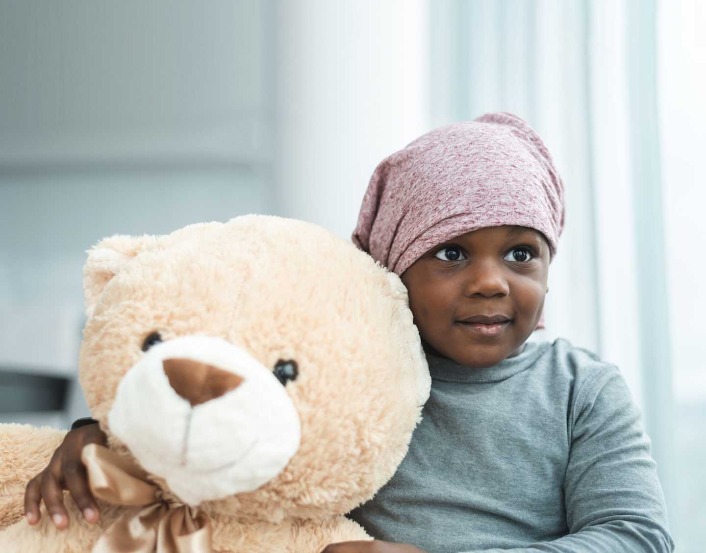 Little girl holding large teddy bear.