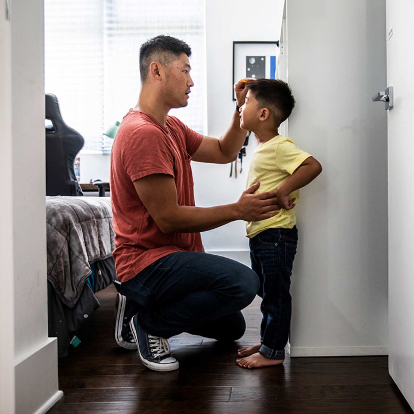 Father measuring height of son.