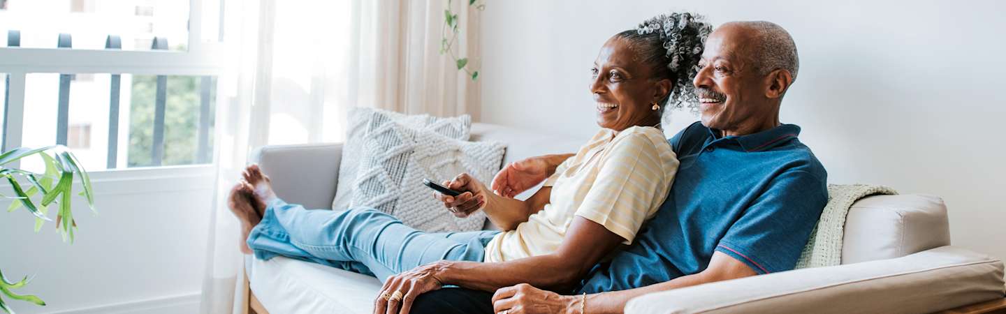 Older couple sitting on couch at home.