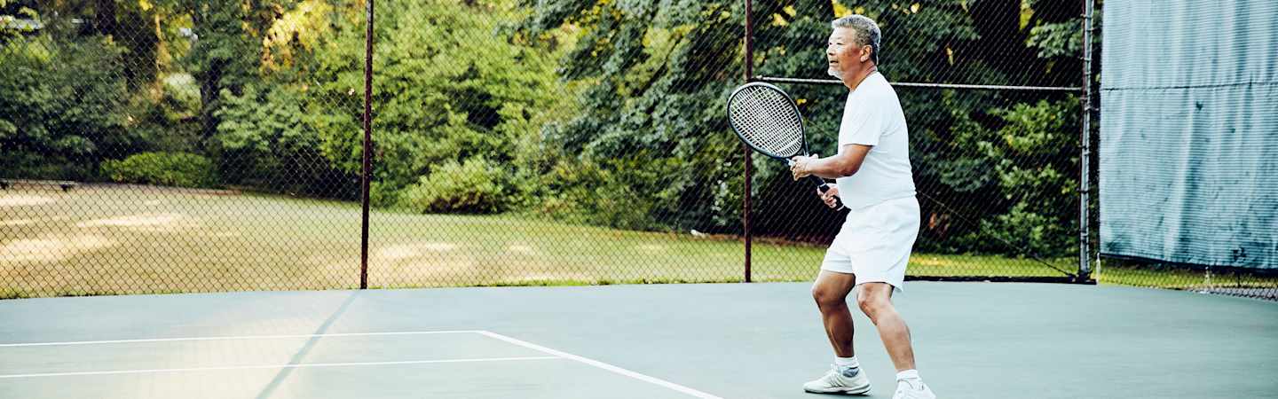 Retired man playing tennis.