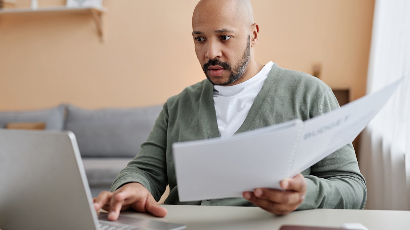 A man looking for over some papers at his desk.