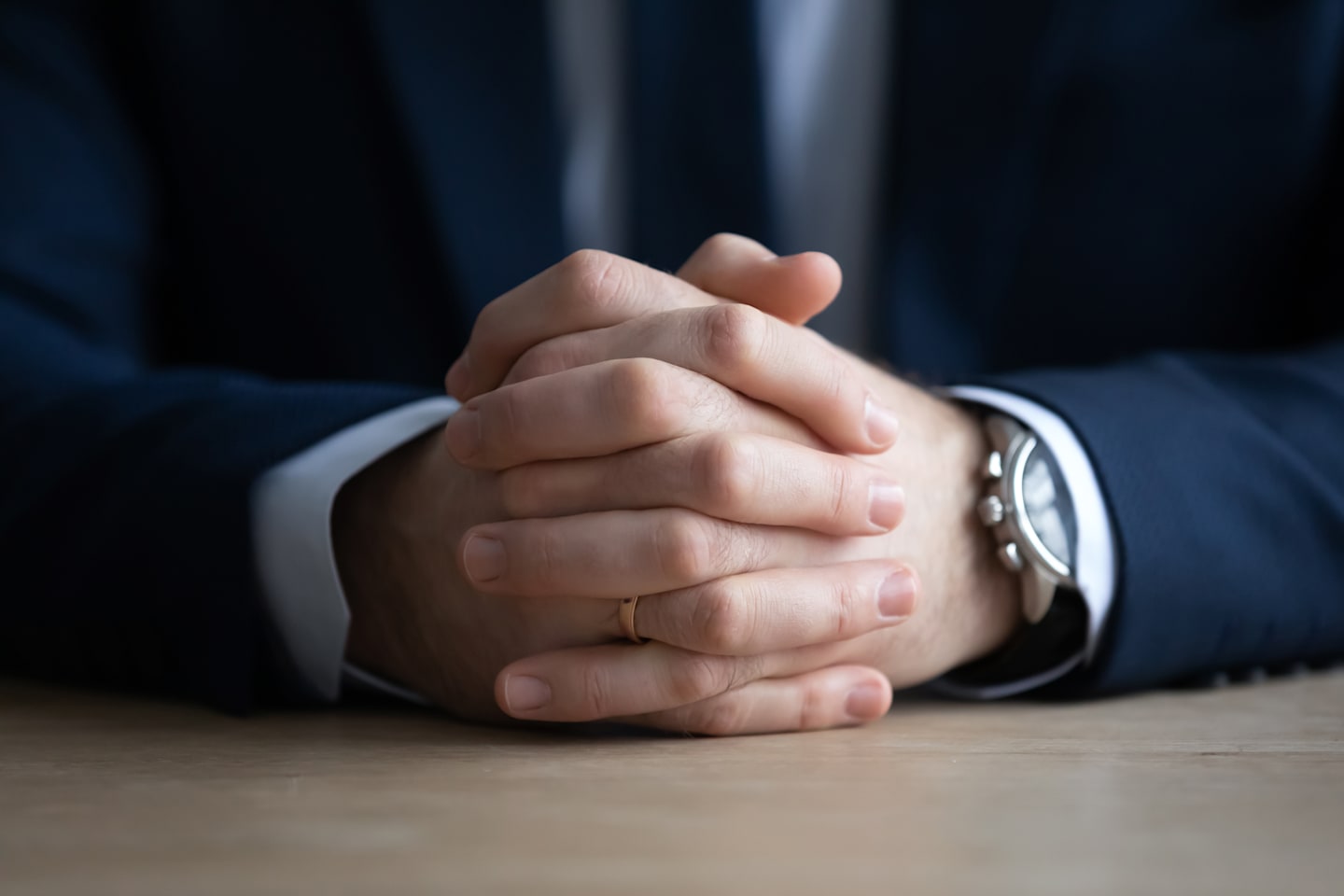 Intertwined set of hands in business suit.