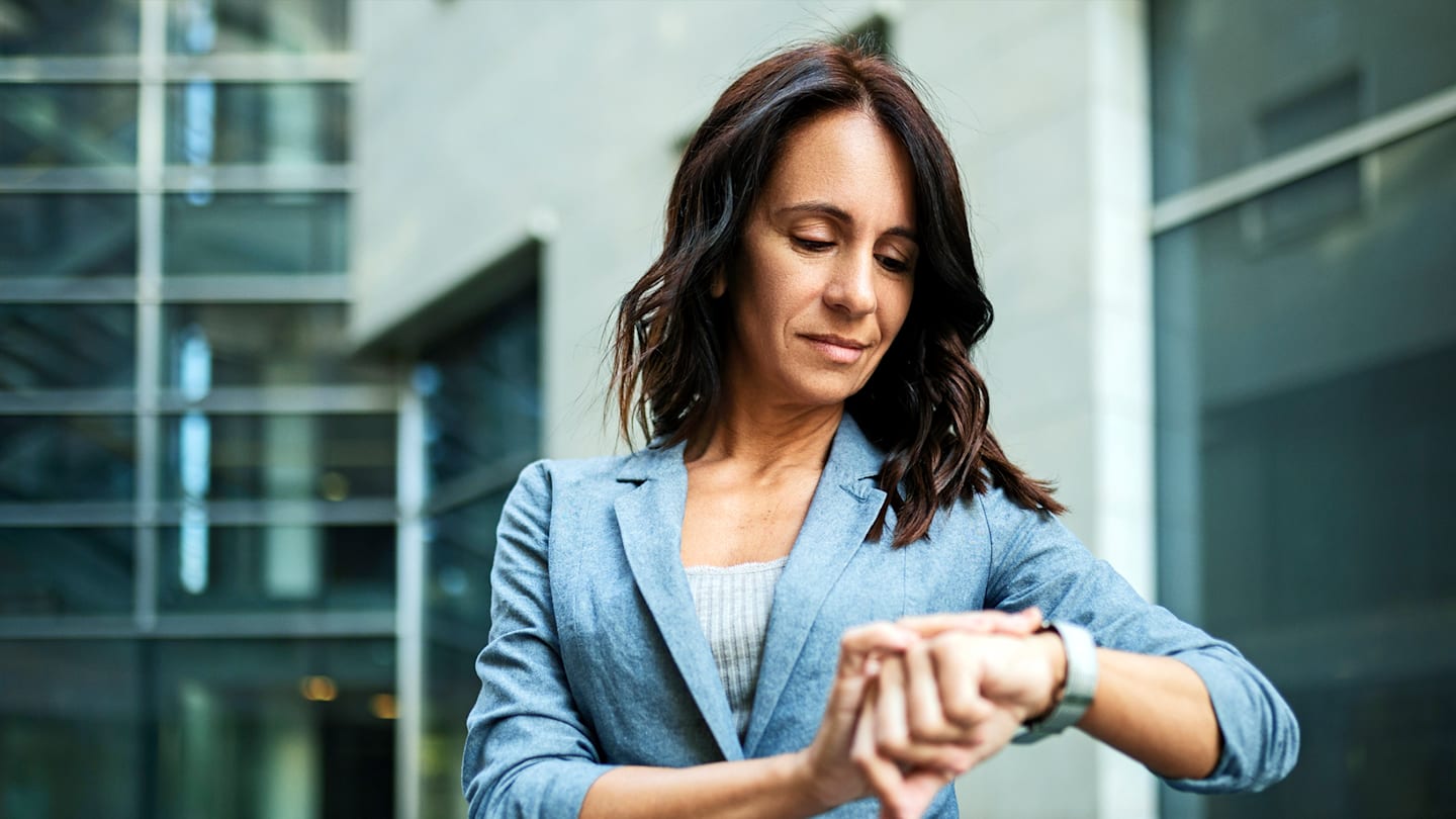 Woman looking at wristwatch.