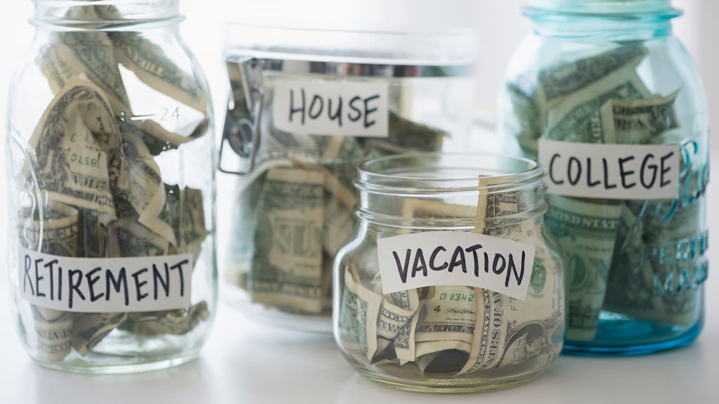 Glass jars hold cash savings for future financial goals: retirement, house, vacation, college.