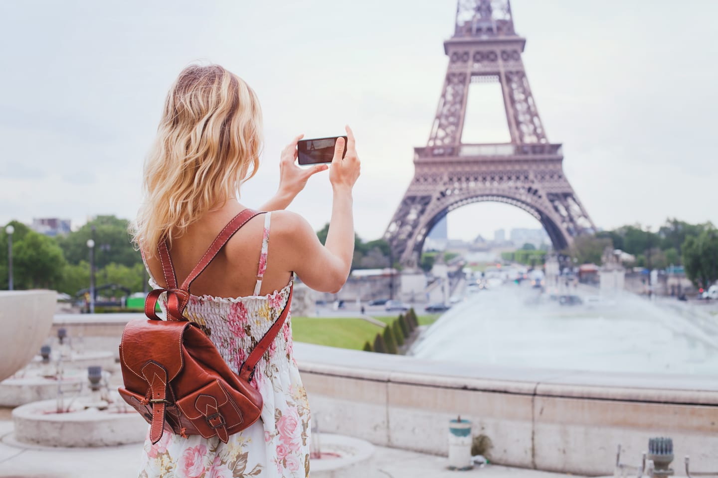 Woman taking photo at Eiffel Tower.