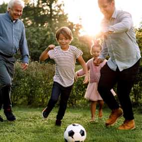 Grandparents playing soccer with grandchildren.