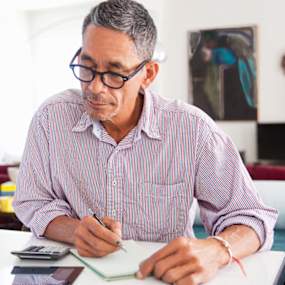 Older man looking over paperwork at home.