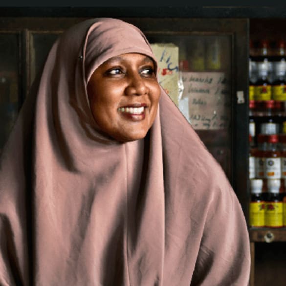 Image of a smiling woman in a small grocery or market