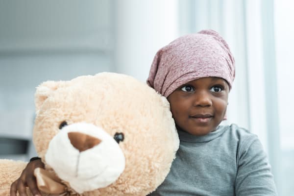 Little girl holding large teddy bear.
