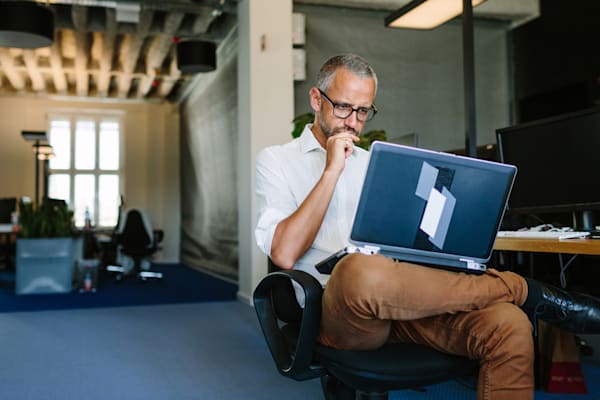 Man with glasses using a laptop